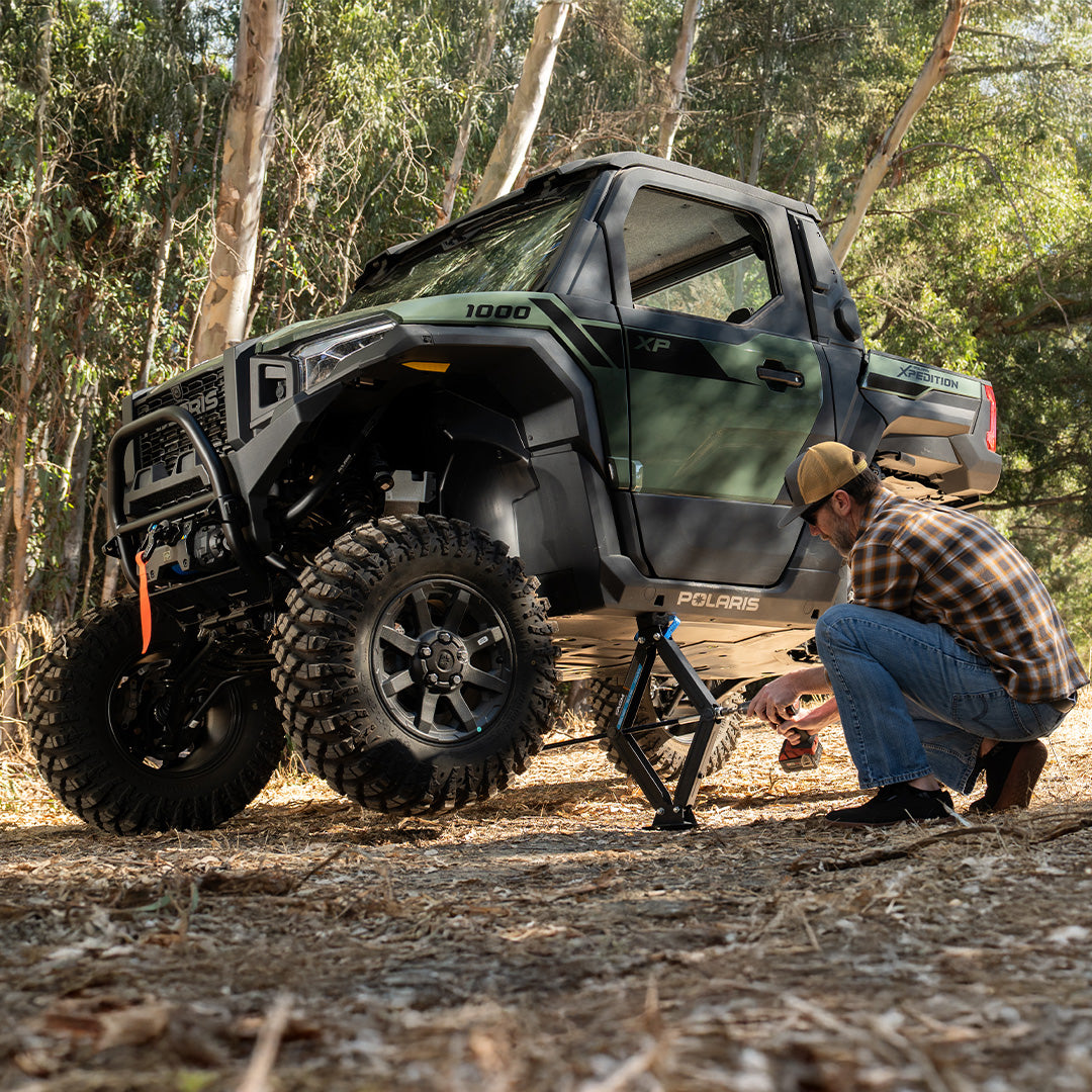 person lifting a Polaris Xpedition with an AGM scissor jack