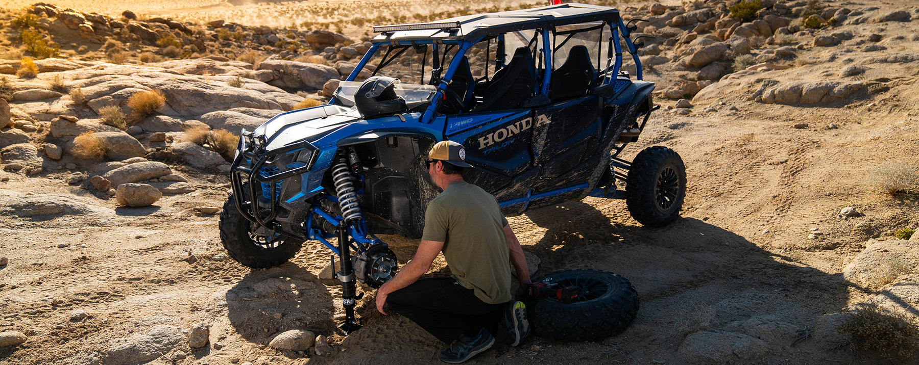 Honda Talon being worked on by a person in a desert setting with AGM Manual Jack PRO