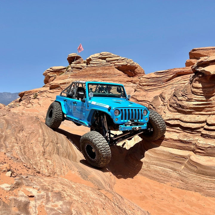 AGM Suspension slider on a blue jeep in the rocks