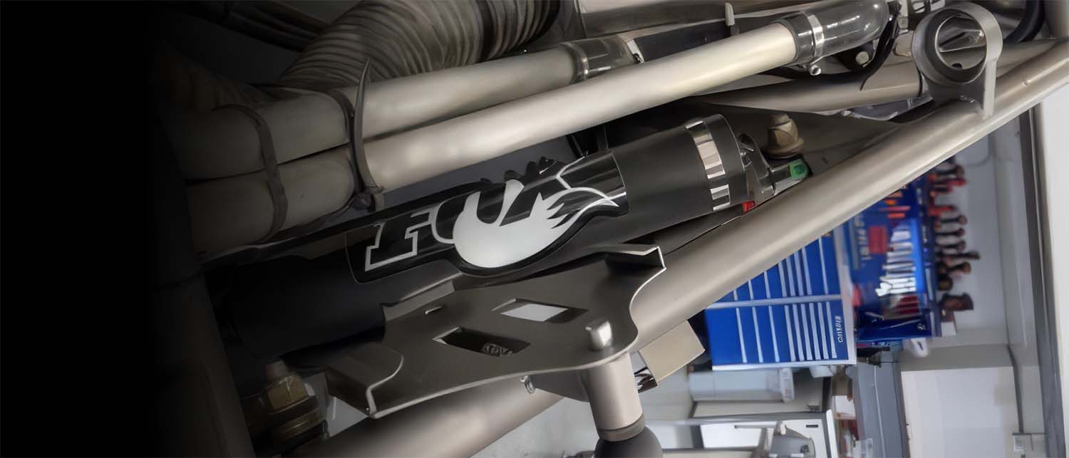 a close-up of an AGM Weld on Pro Jack mount kit installed on an off road car, in a workshop setting.